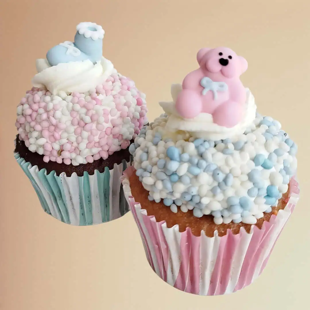 Gender Reveal Cupcakes with pink and blue decorations, sold in multiples of 2, featuring a surprise filling inside.