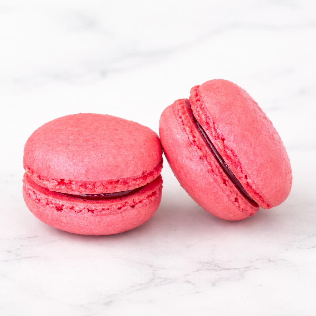 Elegant raspberry macaron with a vibrant filling.