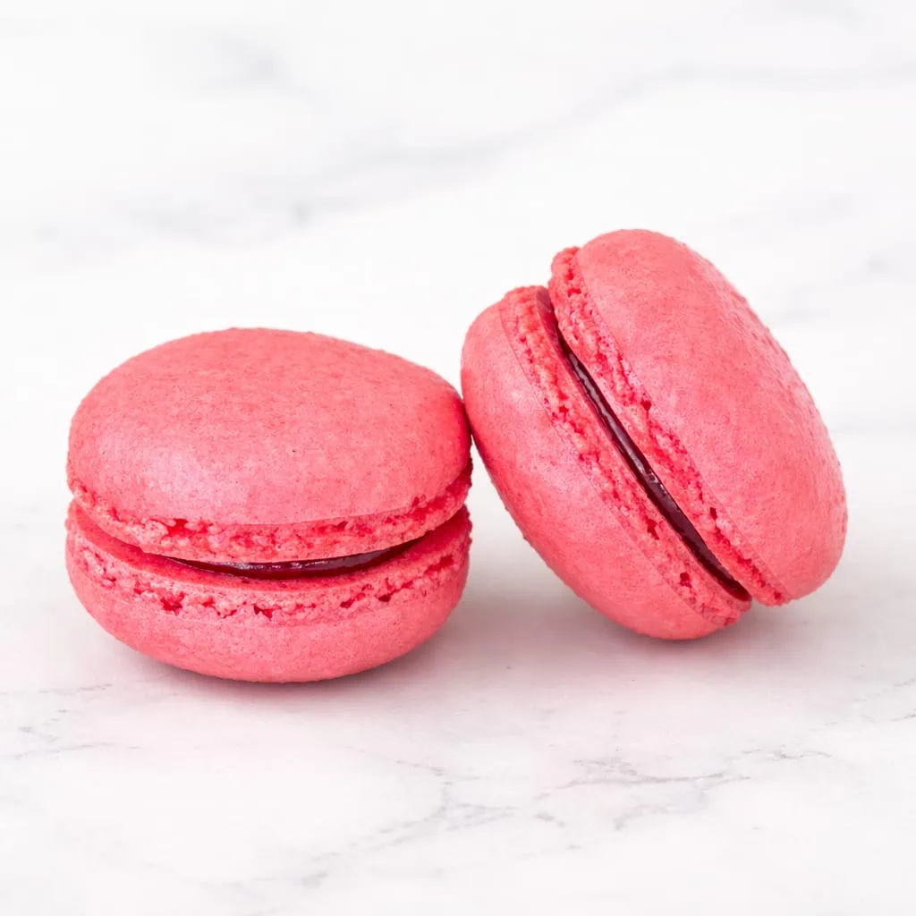 Elegant raspberry macaron with a vibrant filling.