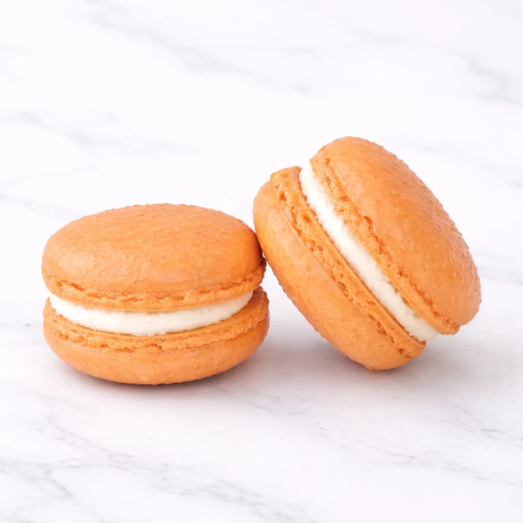 Mango white chocolate macaron with creamy filling.