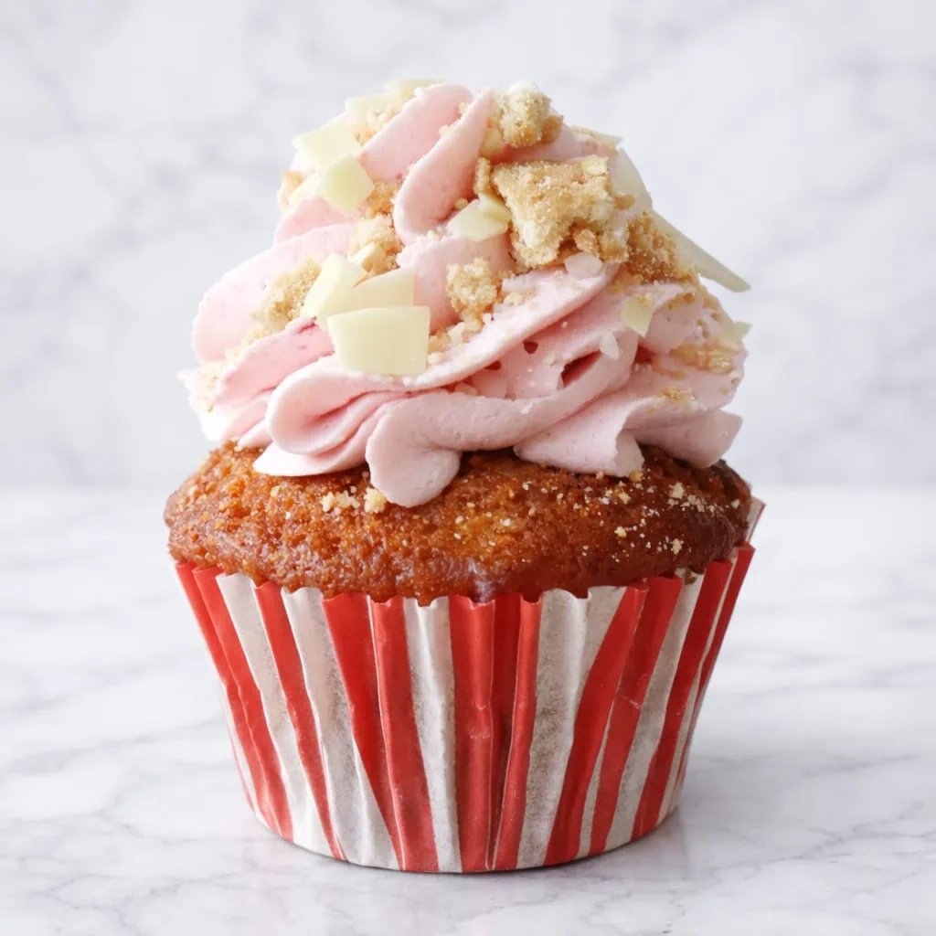 Strawberry cheesecake cupcake with vanilla cake and cream cheese topping.