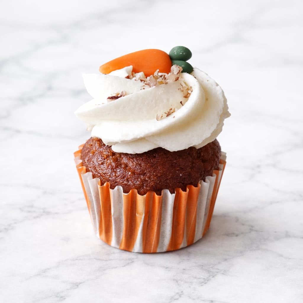 Mini Carrot cupcake with cream cheese frosting and a fondant carrot decoration.