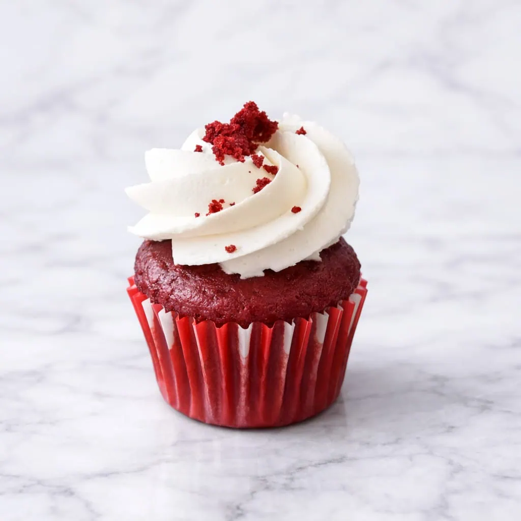 Mini vegan red velvet cupcake with dairy-free frosting.