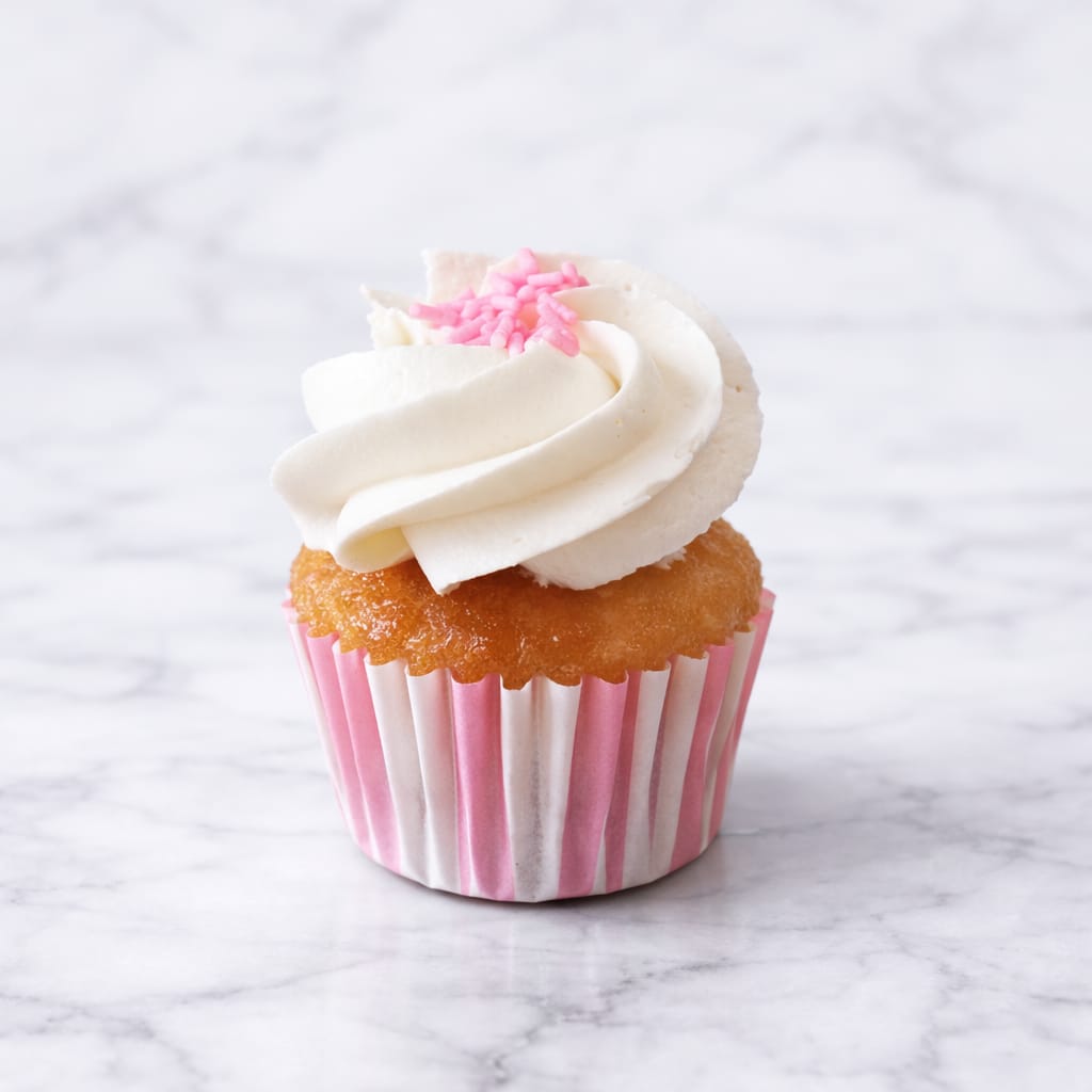 Delicious vegan mini vanilla cupcake on a festive backdrop.