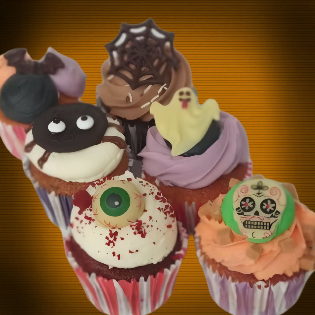 Halloween assorted cupcakes box featuring vanilla with a chocolate bat, strawberry with a white chocolate ghost, chocolate with a spiderweb, Oreo with an Oreo spider, salted caramel with a chocolate skull, and red velvet with a bloodshot eyeball.