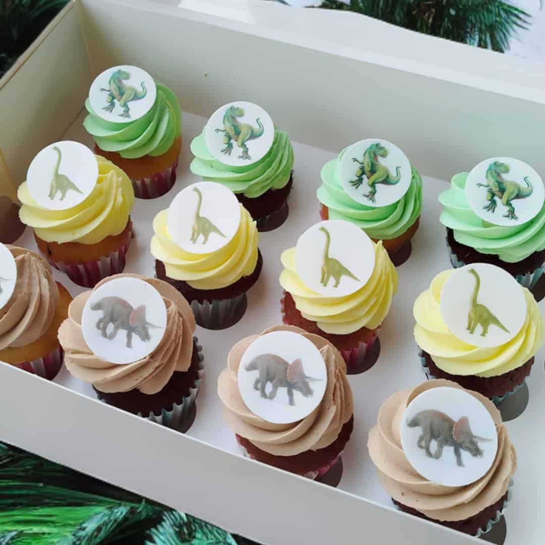 12 Dino Cupcakes Box with colorful fondant dinosaur images on vanilla and chocolate cupcakes, perfect for themed parties and kids’ birthdays.