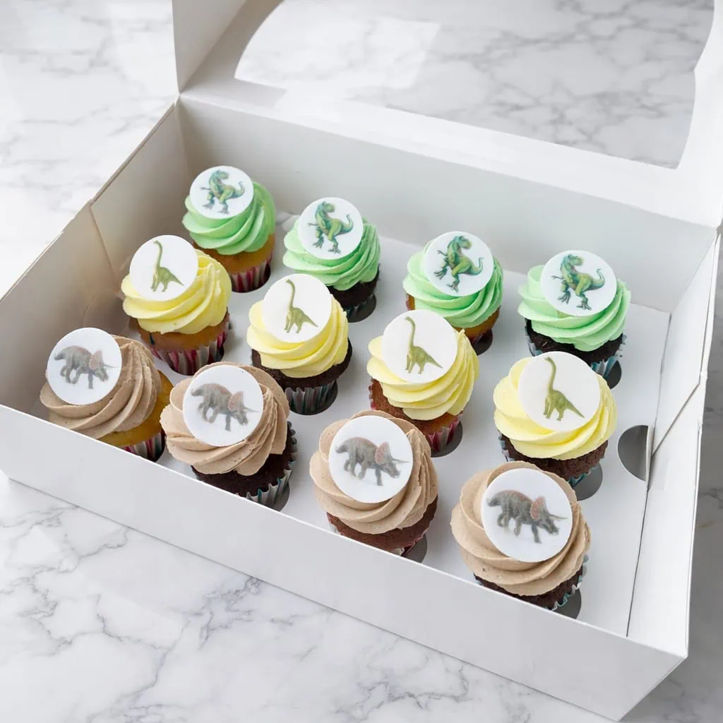 12 Dino Cupcakes Box with colorful fondant dinosaur images on vanilla and chocolate cupcakes, perfect for themed parties and kids’ birthdays.