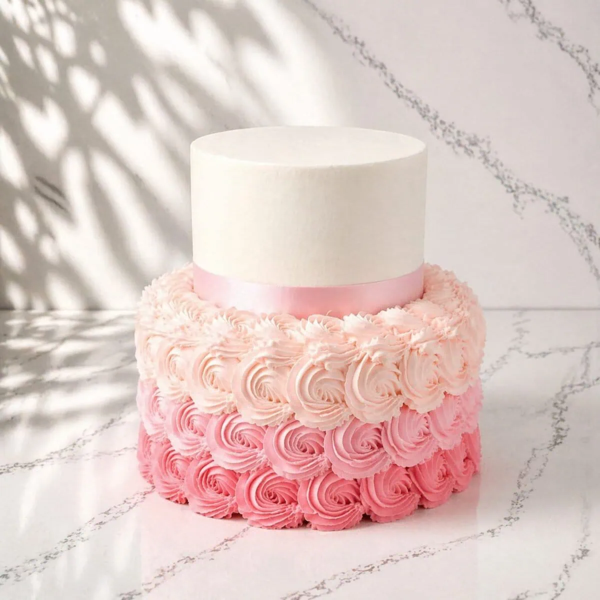 Rose Dream Tier Wedding Cake with a 23 cm bottom tier covered in buttercream roses and a 15 cm top tier in classic wedding style with satin ribbon