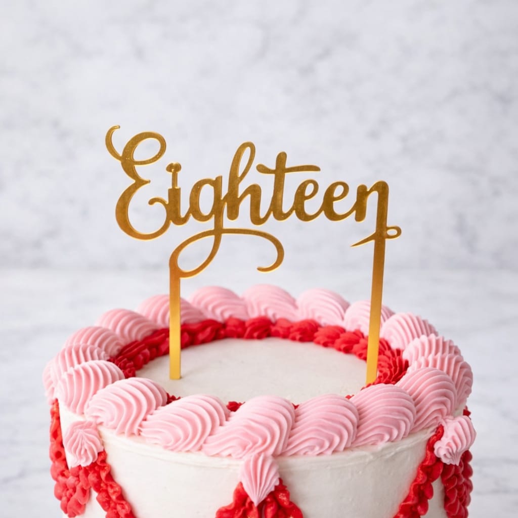 Gold "Eighteen" acrylic cake topper on a festive cake.