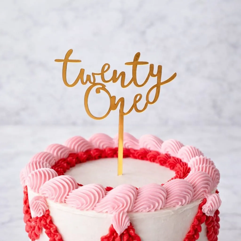 Gold "Twenty One" acrylic cake topper for a birthday cake.