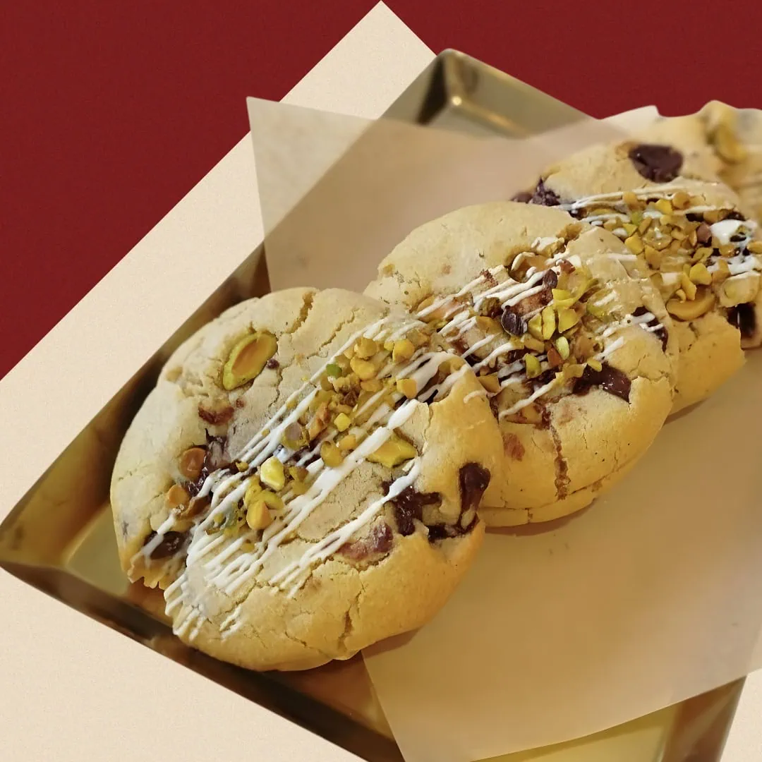 Luxury Dubai Chocolate Pistachio Cookies with white chocolate drizzle on a gold tray