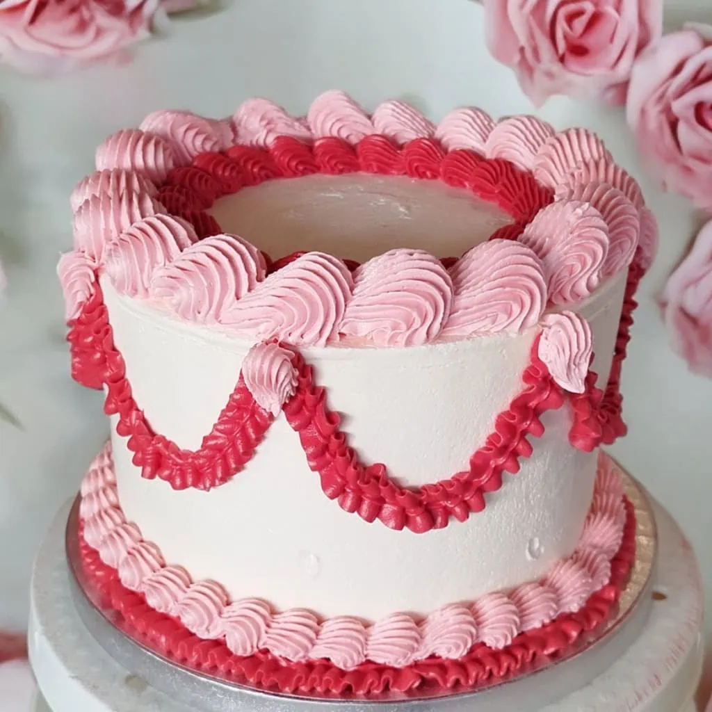 romantic baroque cake with pink and red piping