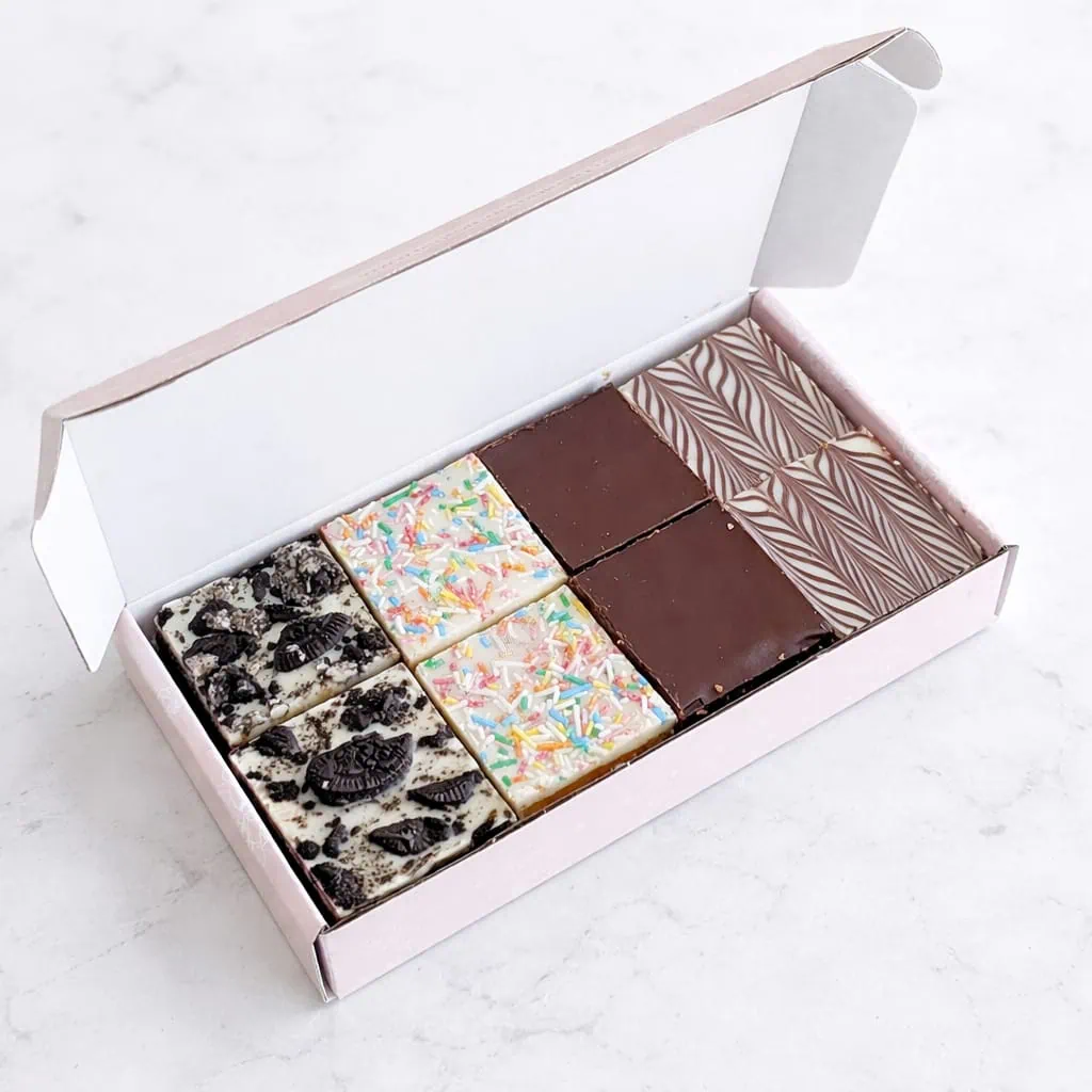 This inviting image displays a letterbox-sized box filled with an assortment of brownie bites, including flavors like Belgian Chocolate, Red Velvet, and Blondie Nutella. The brownie bites are vacuum packed for freshness and arranged elegantly within the box, which is designed for convenient and free delivery across the Netherlands, making it the perfect gift for any sweet tooth