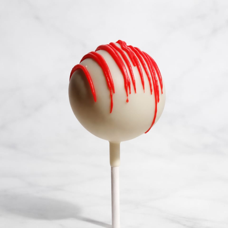 Striped Red velvet cakepop dipped in white chocolate with a delicate red line decoration