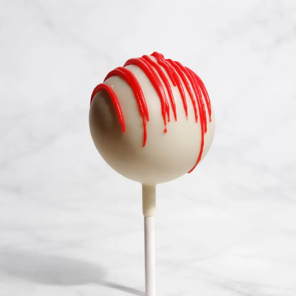 Striped Red velvet cakepop dipped in white chocolate with a delicate red line decoration