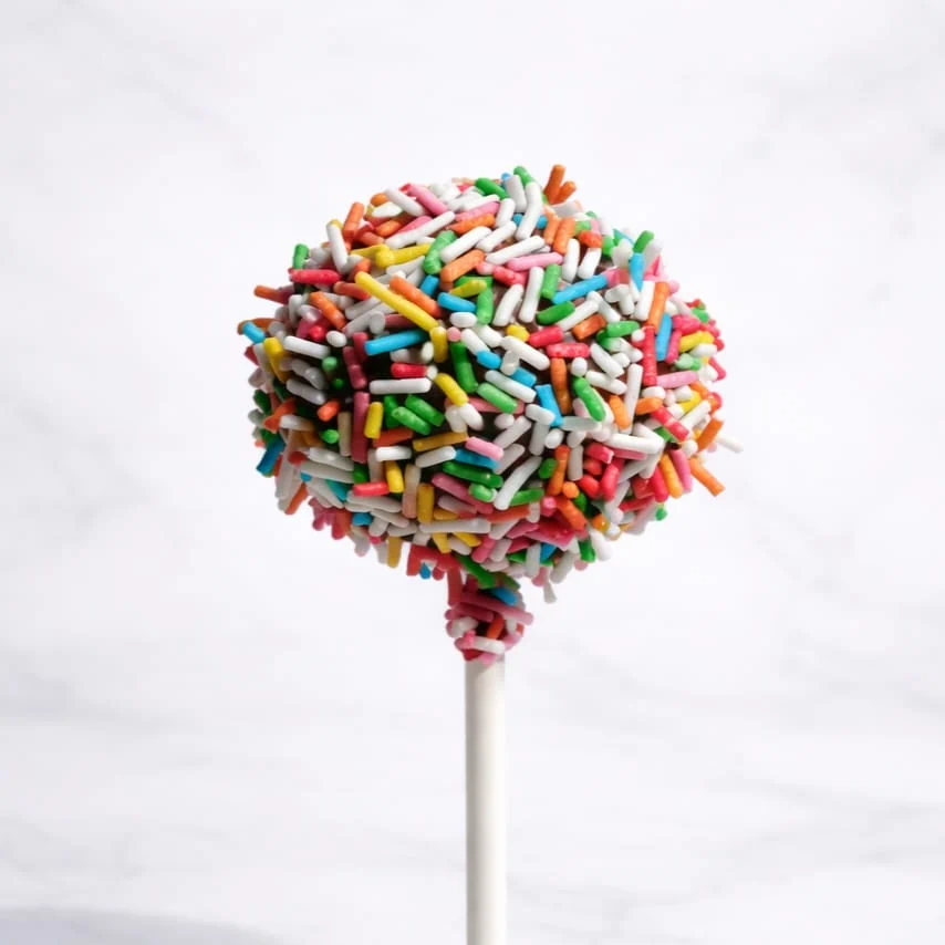 Chocolate cakepop dipped in milk chocolate and decorated with multicolored confetti sprinkles.